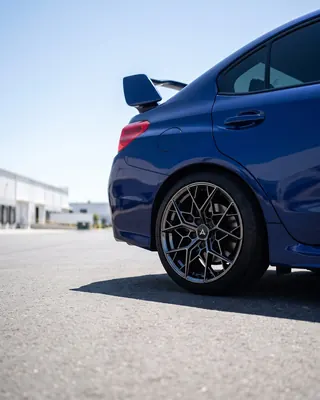 Subaru WRX STI azul con AXYS GAL plateadas, tres cuartos trasero